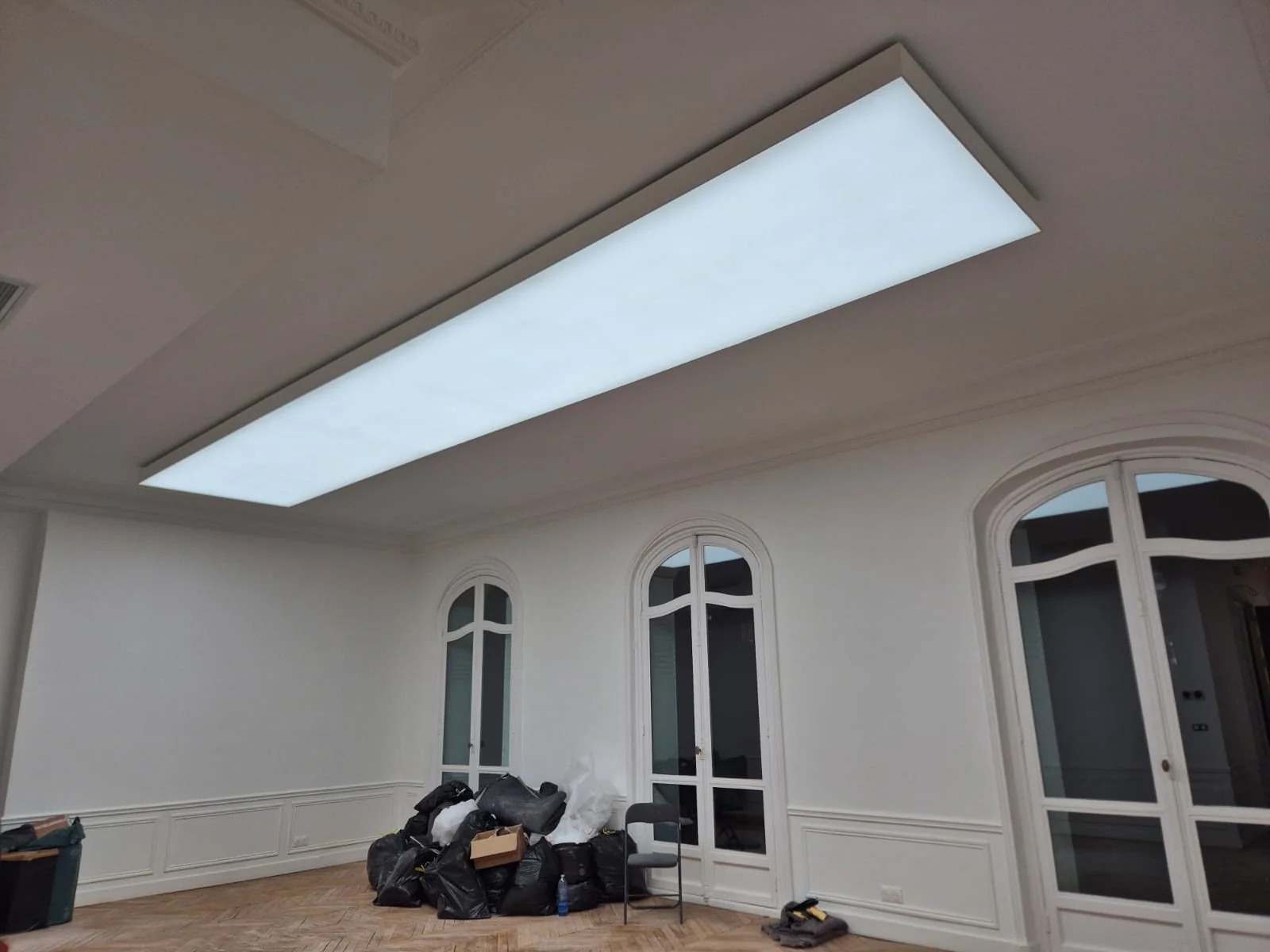 Long luminous lightbox installed within the Paris office ceiling